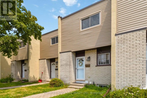 Front view of a townhouse showing beige siding and light colored brickwork. - 19 - 178 Grulke Street, Kitchener