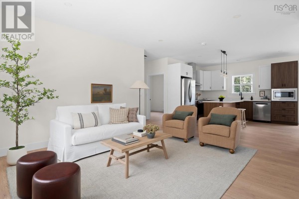 Living room with open-concept view into kitchen, featuring white sofa and island. - 19 Ardoise Lane, Ardoise