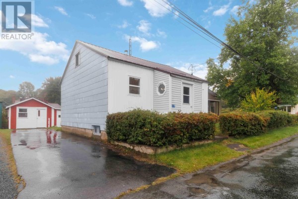 Side view of a small white bungalow with a detached red and white garage. - 19 Central Boulevard, Liverpool