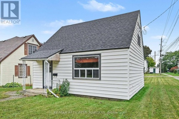 Side view of a white sided bungalow with a black roof and green lawn. - 19 Churchill Crescent, Smiths Falls