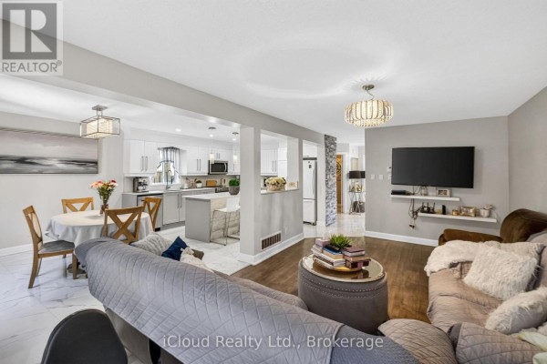 Open-concept living and kitchen area with a dining table, island, and modern furniture. - 19 Crusoe Place, Ingersoll