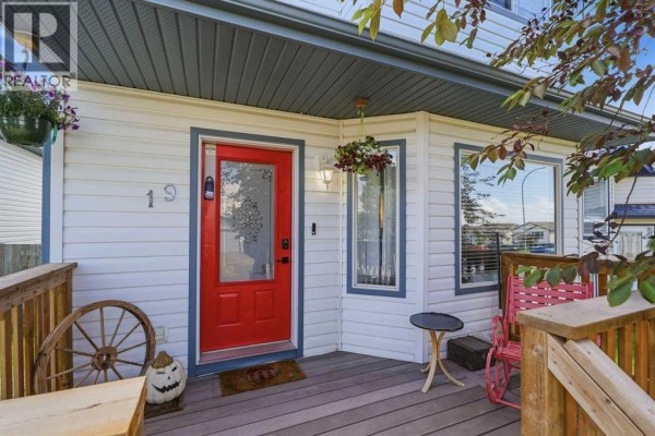 Close-up of the red front door and porch of a white house with wooden railings. - 19 Fenwood Close, Sylvan Lake