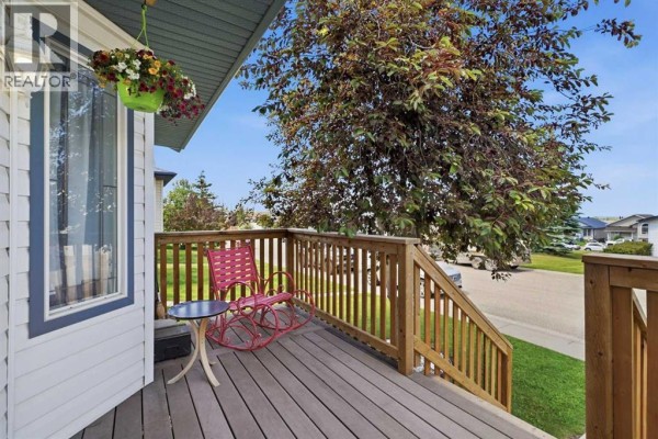 View of the wooden porch and railings on the right side of the house exterior. - 19 Fenwood Close, Sylvan Lake