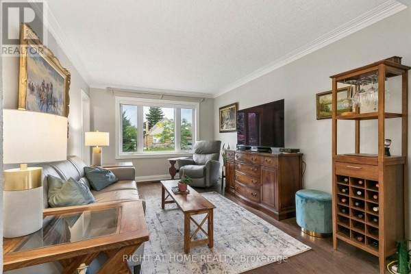 Living room with leather sofa, armchair, coffee table, wooden furniture, and large window. - 19 Flempton Crescent, Toronto