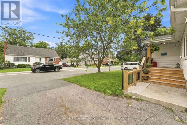View from the street looking towards the house with a driveway and neighbouring properties. - 19 Graham Street E, Greater Napanee