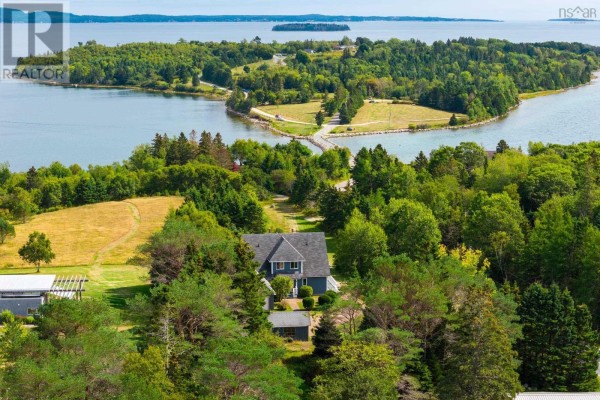 Aerial view of the property near water, showcasing lush greenery and nearby roads. - 19 Graves Island Road, East Chester