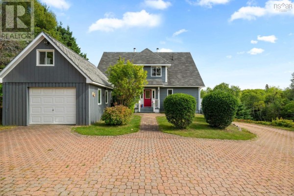 Front view of the home featuring a brick driveway and garage, with landscaped shrubs. - 19 Graves Island Road, East Chester