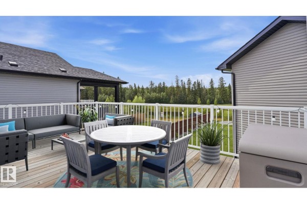 Aerial view of a residential street with multiple houses and a treeline in the background. - 19 Holt Cv, Spruce Grove