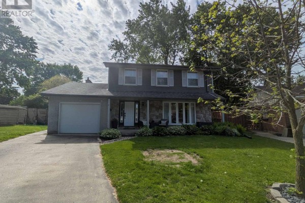 Front exterior of a grey two-story house with a large lawn and mature trees. - 19 Kendall Court, London North