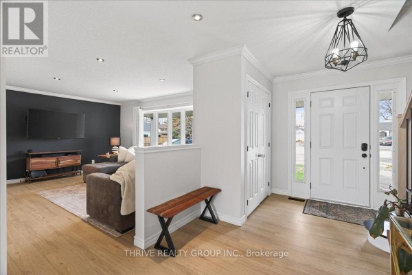 Interior entryway with white double doors, light wood floors, and a view into the living room. - 19 Kendall Court, London North