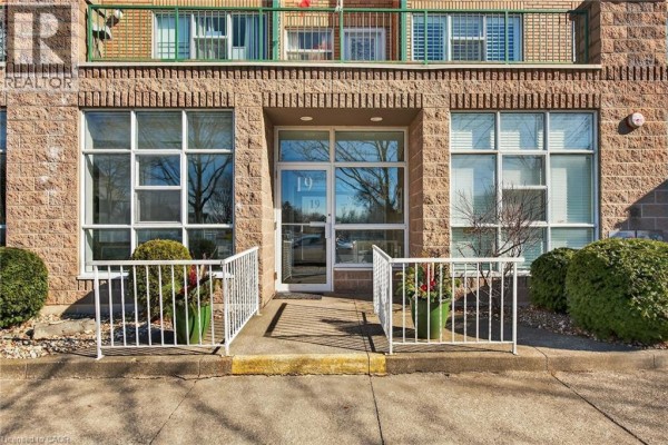 Entrance area with double doors, decorative planters, and accessibility ramp. - 19 Lake Avenue S Unit# 303, Stoney Creek