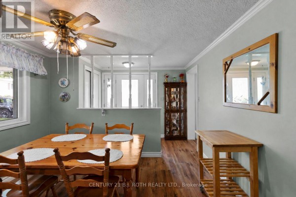 Dining room with a wooden table, chairs, mirror, and decorative cabinet. - 19 Maple Crescent, Oro Medonte
