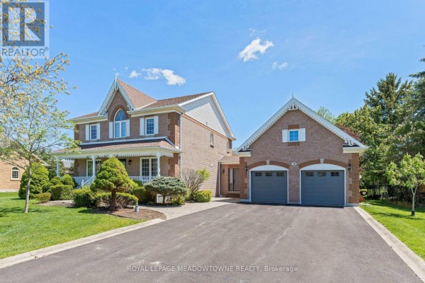 Side view of a brick house with a large driveway leading to an attached two-car garage. - 19 Mccullogh Drive, Erin