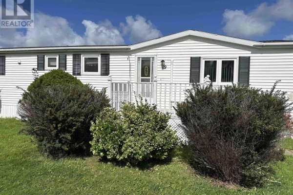 Close-up of the white mobile home entrance with a white railing and green shrubs. - 19 Old Wharf Road, Havre Boucher