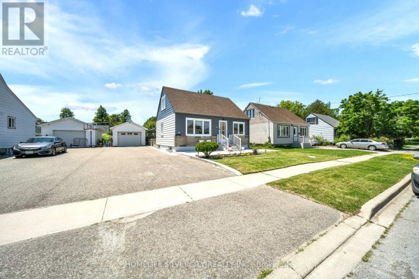 Side view of the bungalow, driveway, and neighboring houses on a sunny day. - 19 Pleasantview Avenue, Brampton