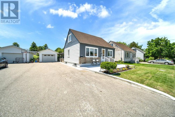 The bungalow's front entrance and stone facade are visible from the driveway on a clear day. - 19 Pleasantview Avenue, Brampton