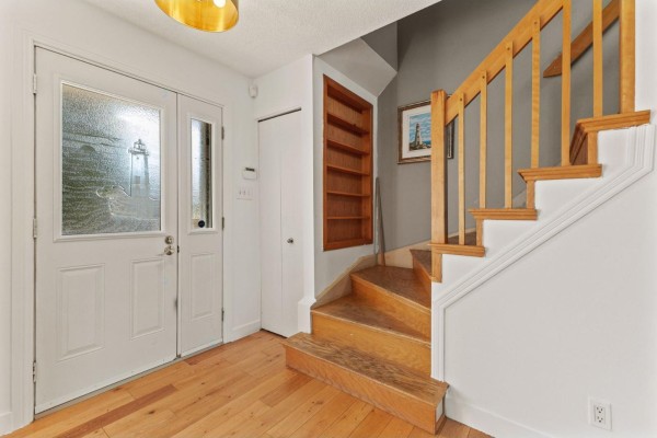 Interior entryway with double doors, wood floors, and wooden staircase. - 19 Rue Des Graves, Gatineau