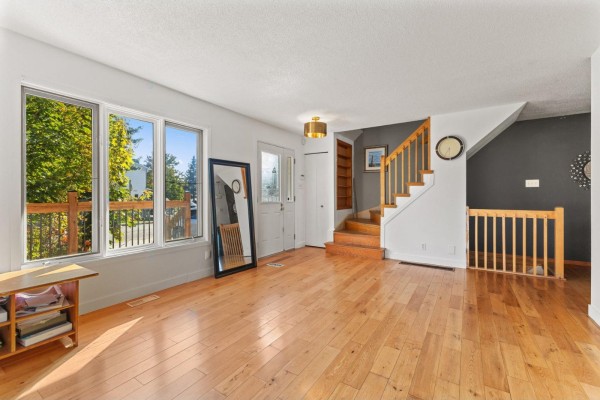 Living room with large windows, wood floors, and view of trees. - 19 Rue Des Graves, Gatineau