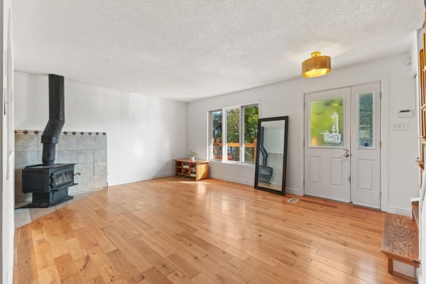 Living room with a wood stove, wood floors, and double doors. - 19 Rue Des Graves, Gatineau