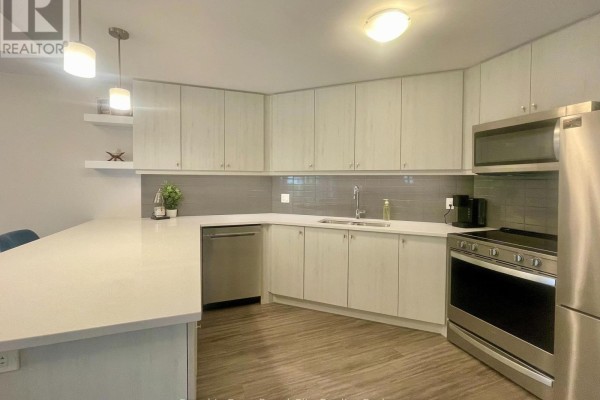 Modern kitchen with light wood cabinets, white countertops, stainless steel appliances, and a subway tile backsplash. - 101 - 19 Stumpf Street, Centre Wellington