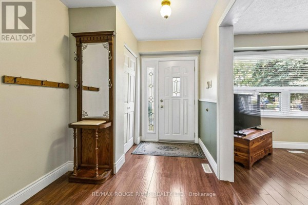 Interior entryway with wood flooring, coat rack, mirror, and glass-panelled door. - 19 Tinbury Place, Toronto