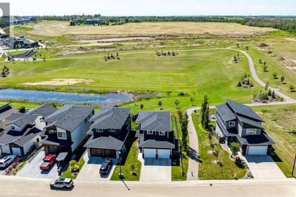 Open field view with snow patches and distant homes. - 19 Vanveller Way, Sylvan Lake