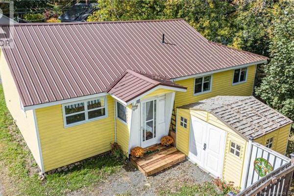 Rear view of a yellow house with a brown metal roof and an attached yellow shed. - 19 Victory Avenue, Fredericton