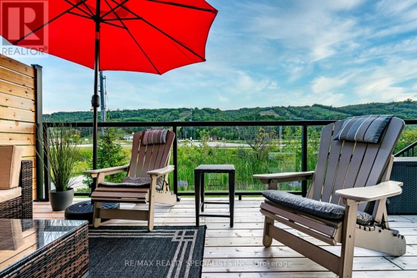 Outdoor deck with Adirondack chairs, a red umbrella, and views of rolling green hills. - 190 Courtland Street, Blue Mountains