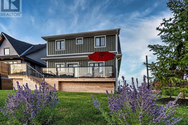 Modern house with wooden deck, glass railings, and red umbrella - Blue Mountains