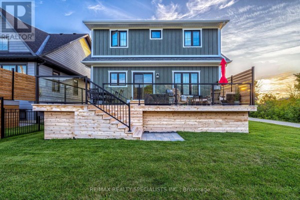 Modern backyard with wooden deck, glass railing, outdoor seating, and red umbrella - 190 Courtland Street Blue Mountains