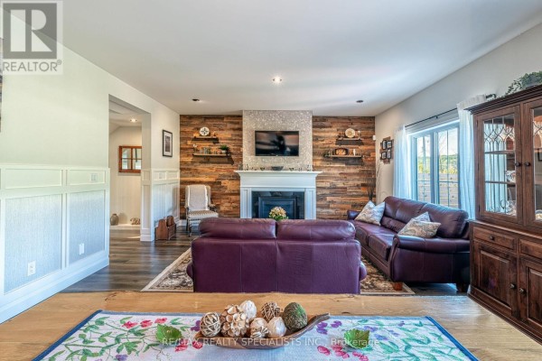 Living room with fireplace, TV, wood accent wall, leather sofa, and china cabinet - 190 Courtland Street Blue Mountains