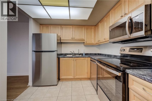 Interior lobby with dark granite, wood paneling, a reception desk, and glass doors. - 190 Hespeler Road Unit# 905, Cambridge