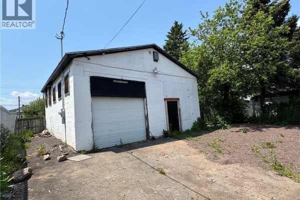 Side and front view of a white detached garage building with large overhead door. - 190 Spruce Street, Moncton