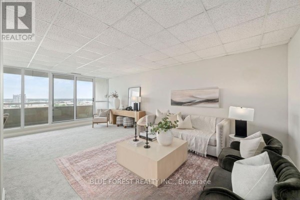 Spacious living room with large windows and city views. - 1901 - 389 Dundas Street, London East