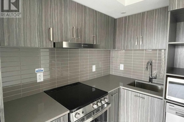 Detailed view of a modern apartment kitchen counter with sink, faucet, and stovetop. - 1902 - 219 Dundas Street E, Toronto