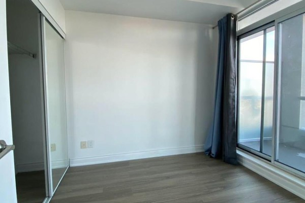 Bedroom with large window, closet space, and light-colored walls - 1904 - 30 Herons Hill Way, Toronto