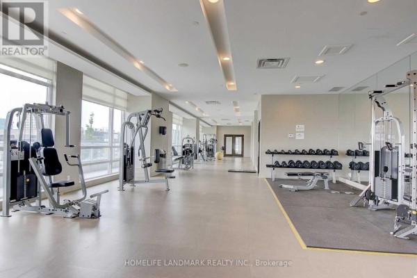 Modern gym with various exercise equipment and large windows - 1904 - 30 Herons Hill Way, Toronto