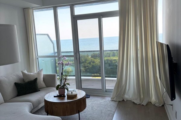 View from the living room window showing water and green trees. - 1905 - 80 Marine Parade Drive, Toronto