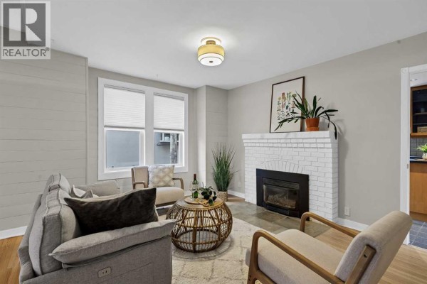 Interior foyer with slate tile floor, carpeted staircase, and doorways to living room and kitchen. - 1905 2 Street Nw, Calgary
