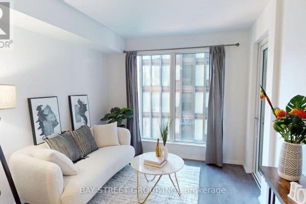 Living area with sofa, coffee table, and window overlooking the city. - 1906 - 68 Shuter Street, Toronto