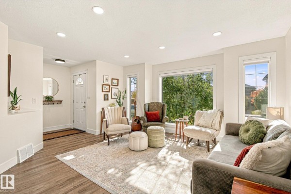 Living room with beige walls, a large picture window, and upholstered furniture. - 1908 36 Av Nw, Edmonton