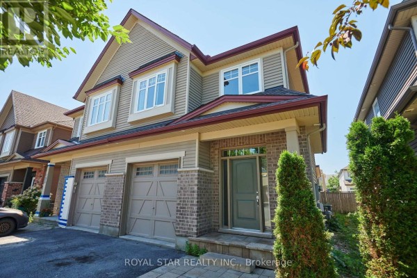 Low angle exterior view of the house, highlighting the tan siding, brick base, and covered front porch. - 191 Flat Sedge Crescent, Ottawa