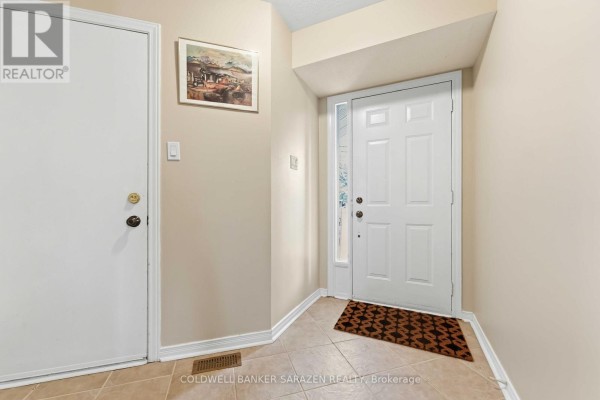 Interior foyer with a closed white door, a main entrance door, and beige walls. - 191 Markland Crescent, Ottawa
