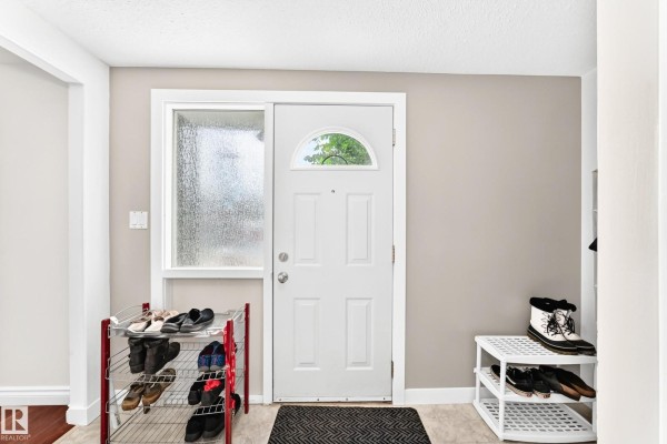 Interior entryway with white door, shoe racks, and grey walls. - 191 Ridgewood Tc, St  Albert