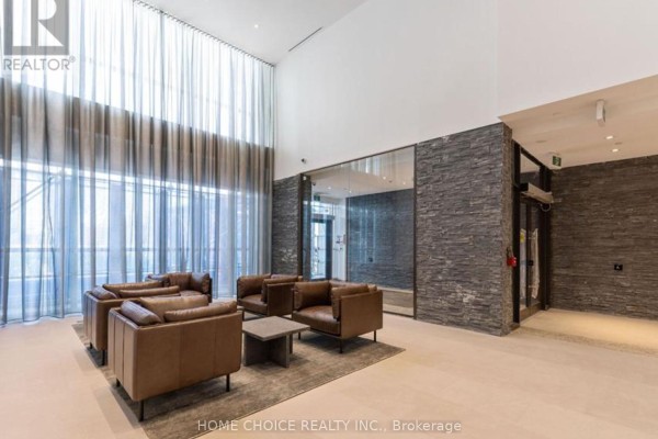 A bright, modern lobby with leather seating, stone accent walls, and floor-to-ceiling curtains. - 1910 - 10 Deerlick Court, Toronto