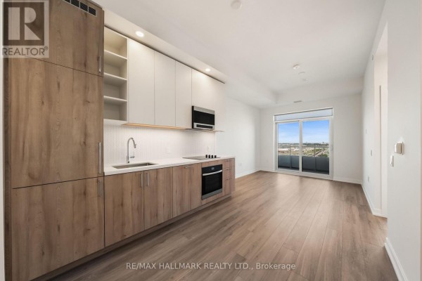 Modern kitchen and living area with light wood floors, white and wood cabinets, stainless steel appliances, and a balcony view. - 1910 - 21 Meadowdale Road, Vaughan
