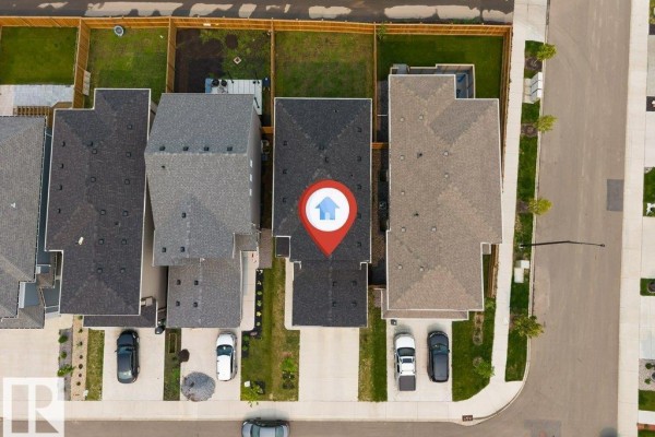 Aerial view of the residential neighborhood showing houses, streets, and a central pond. - 1910 159 St Sw, Edmonton