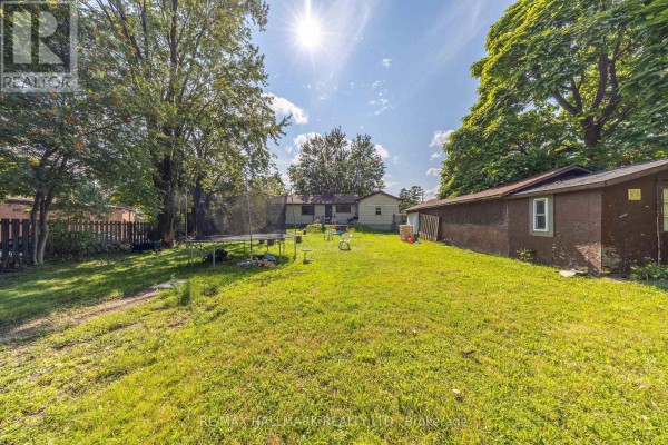 Exterior view of front porch, gravel driveway, and nearby street - 1911 Glenview Road, Pickering