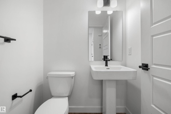 Hallway leading to kitchen with light-colored flooring and blue cabinetry - 19111 20 Av Nw, Edmonton