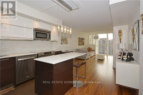 View of the open living space, kitchen island, and balcony with city view. - 1912 - 15 Maitland Place, Toronto